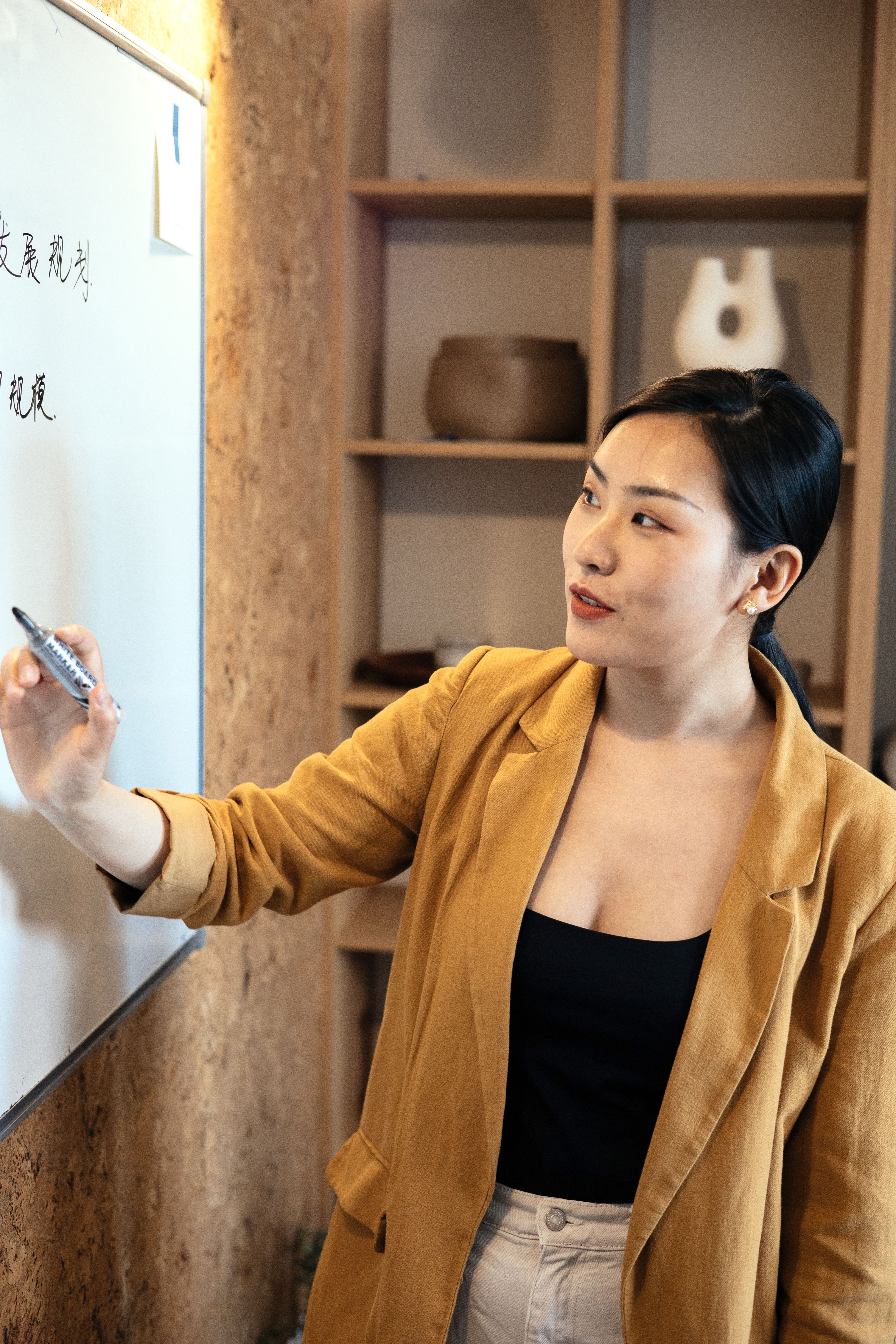 Woman presenting ideas on a whiteboard during a team meeting